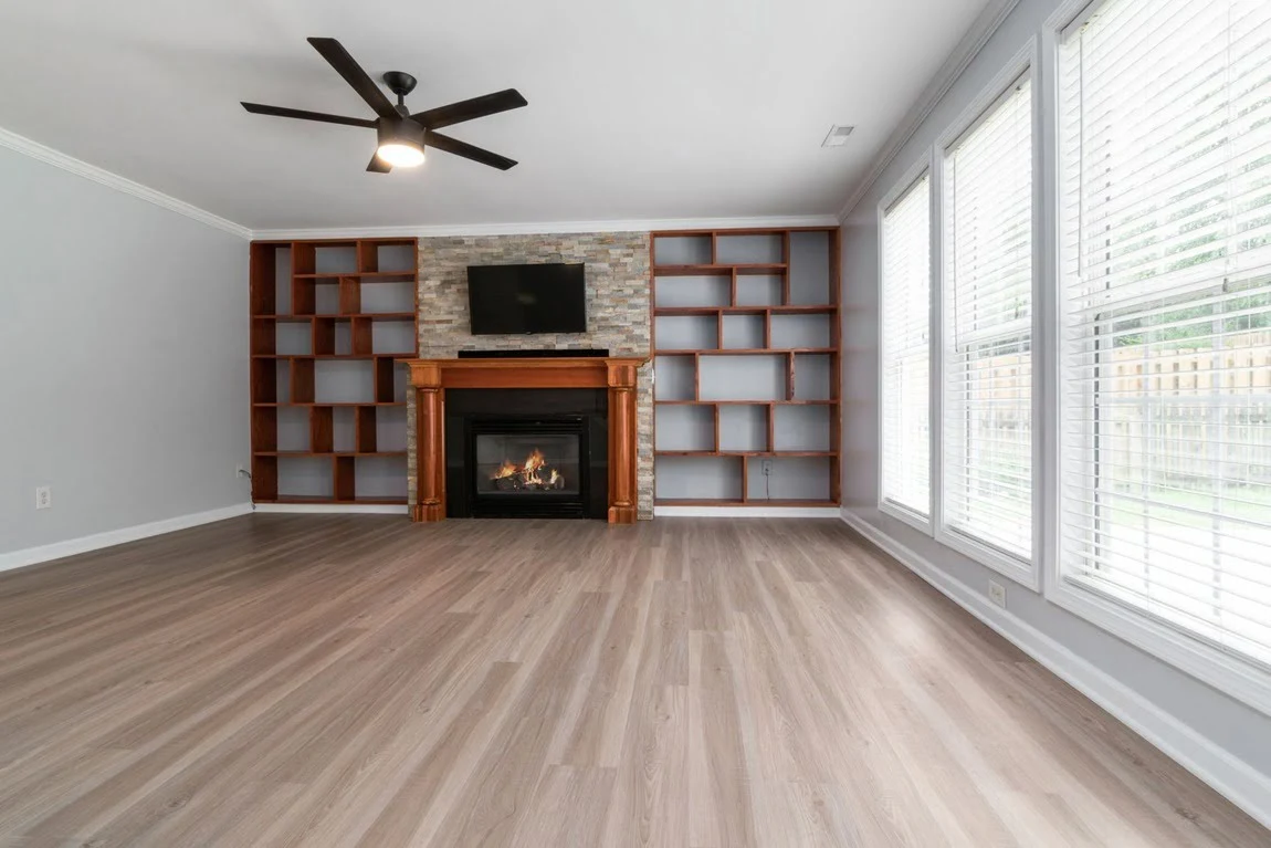 A empty living room with newly installed luxury vinyl plank flooring.